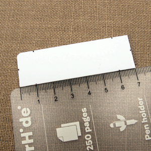 lastic rectangle with marked points for cutting, aligned with a ruler.