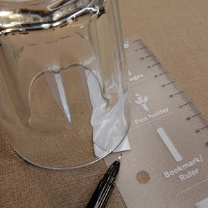 Plastic rectangle with a glass used as a template to draw a curved line with a marker